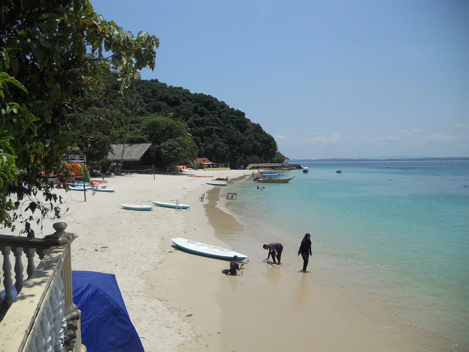 Small boats resting in a sheltered bay at Kapas Island.