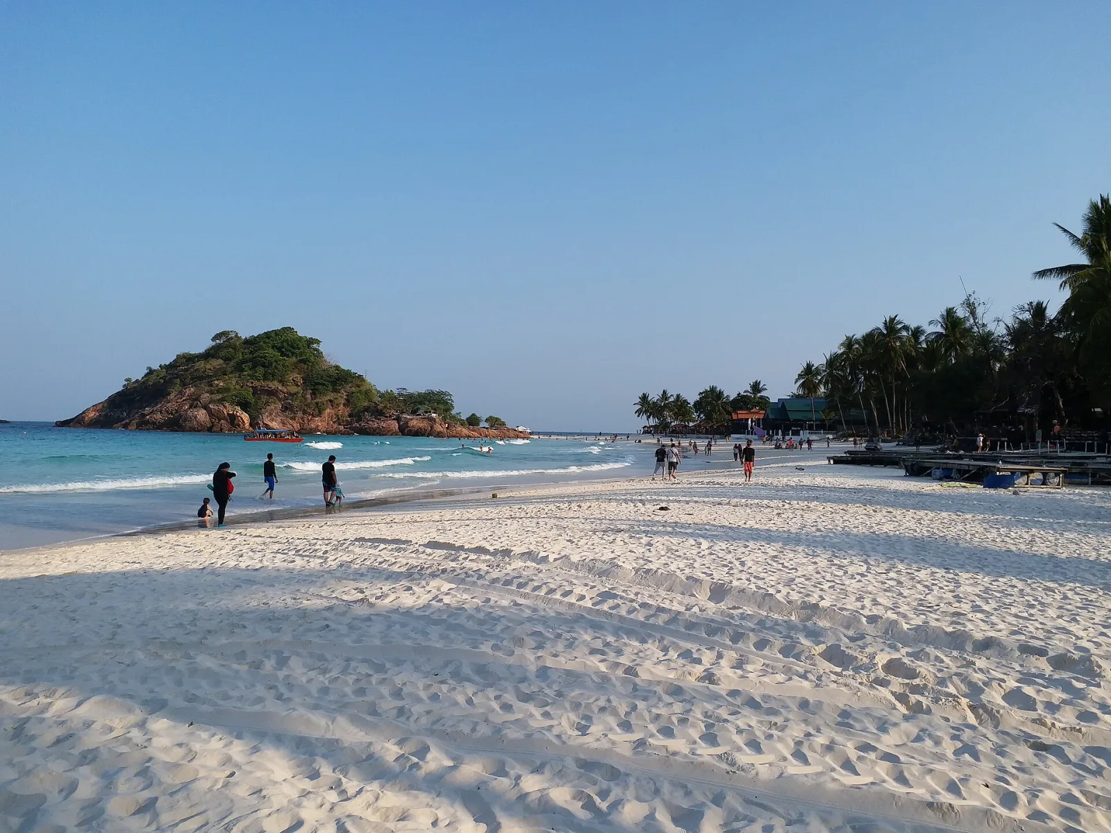 A wide white beach and a small green island at Pulau Redang.